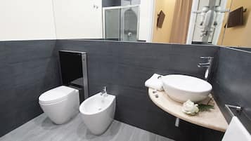 A modern bathroom with a bidet, toilet, and sink.