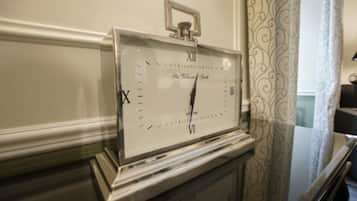 A wall-mounted clock with Roman numerals and a pendulum.