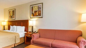 Ein Hotelzimmer mit einem Bett, einem Sofa, einem Tisch und zwei Lampen.