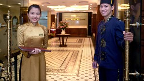 A hotel lobby with a reception desk, a decorative vase, and a patterned floor. - Hanoi Emotion Hotel (Hanoi)