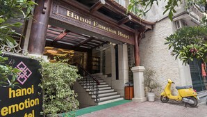 The Hanoi Emotion Hotel entrance with a staircase leading to the lobby, a yellow scooter parked outside, and a signboard with the hotel's name. - Hanoi Emotion Hotel (Hanoi)