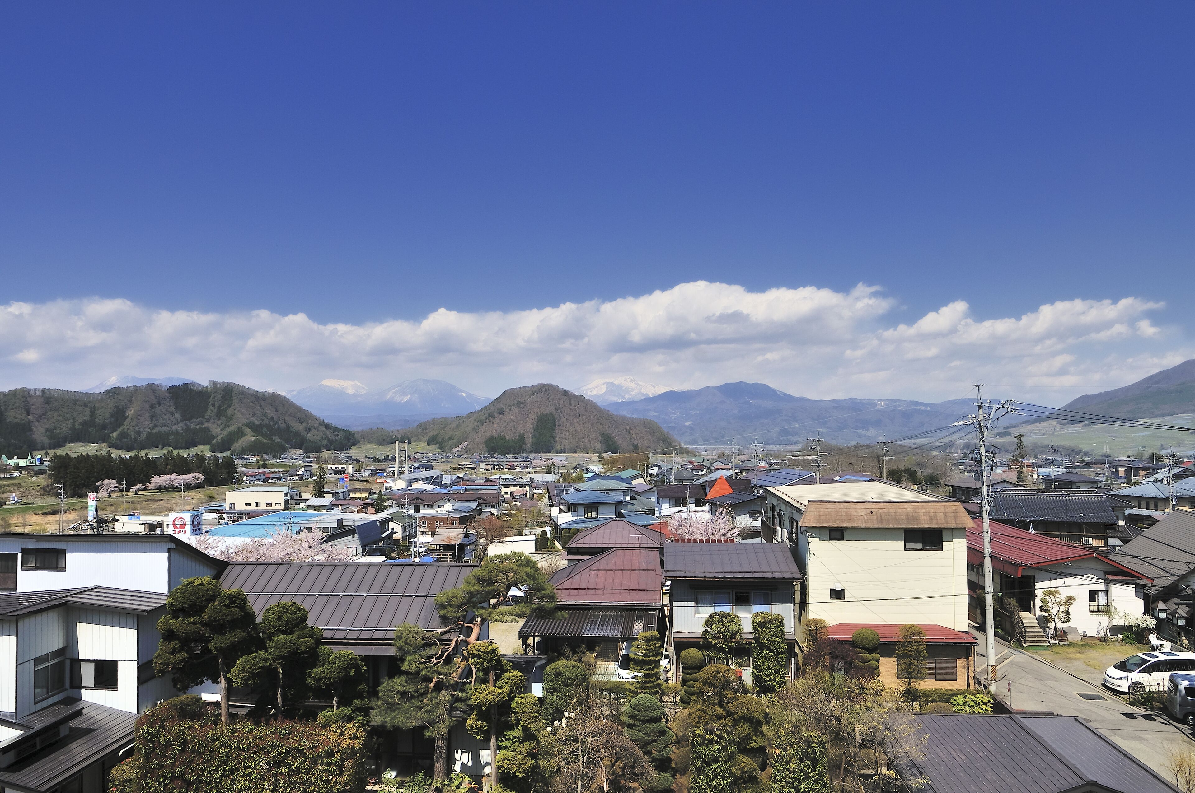 A residential area with houses, a swimming pool, and mountains in the background.