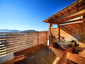 Un spa en bois doté d’un bain à remous et offrant une vue sur les montagnes.