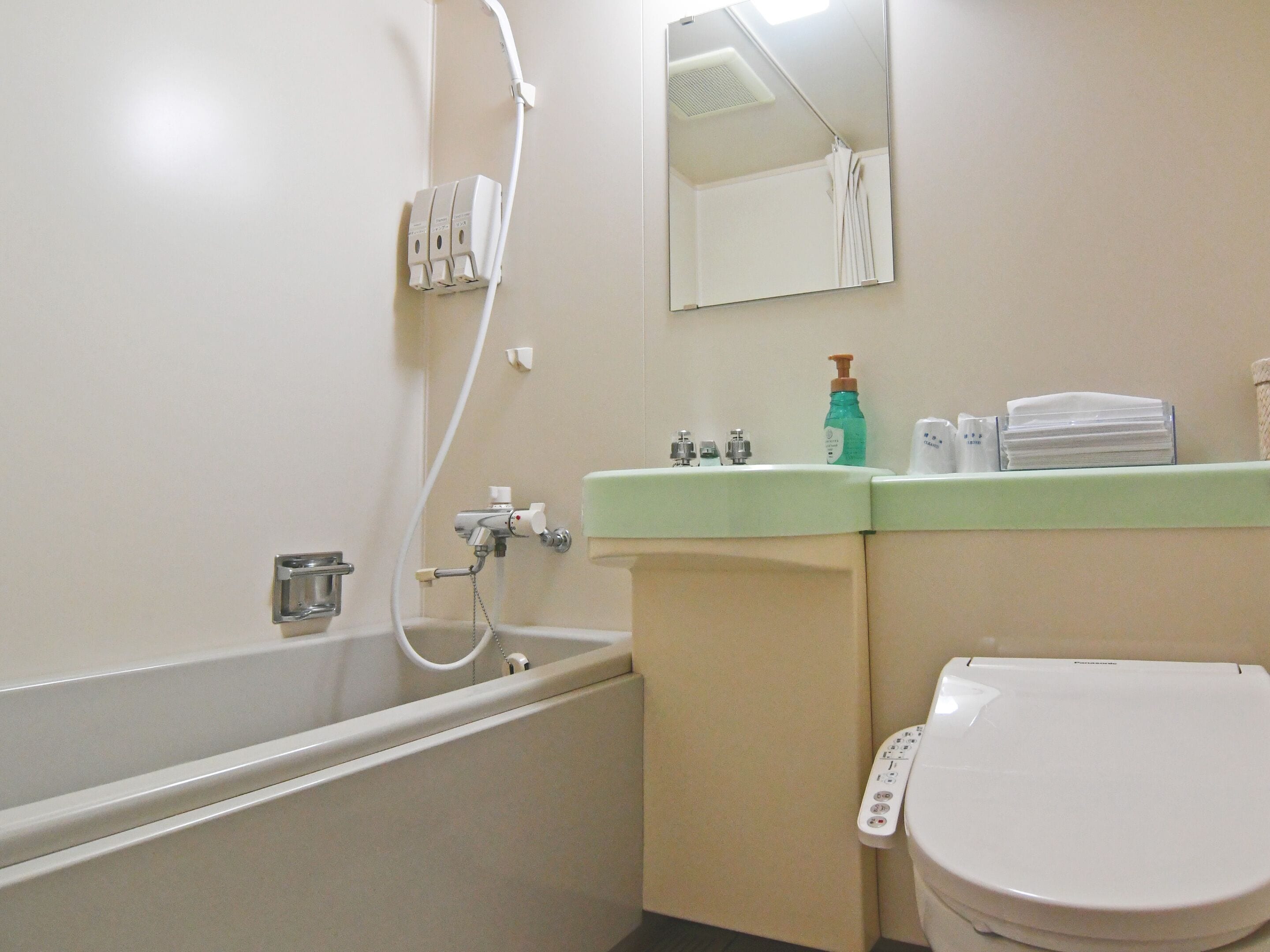 A bathroom with a bathtub, toilet, sink, and a mirror.