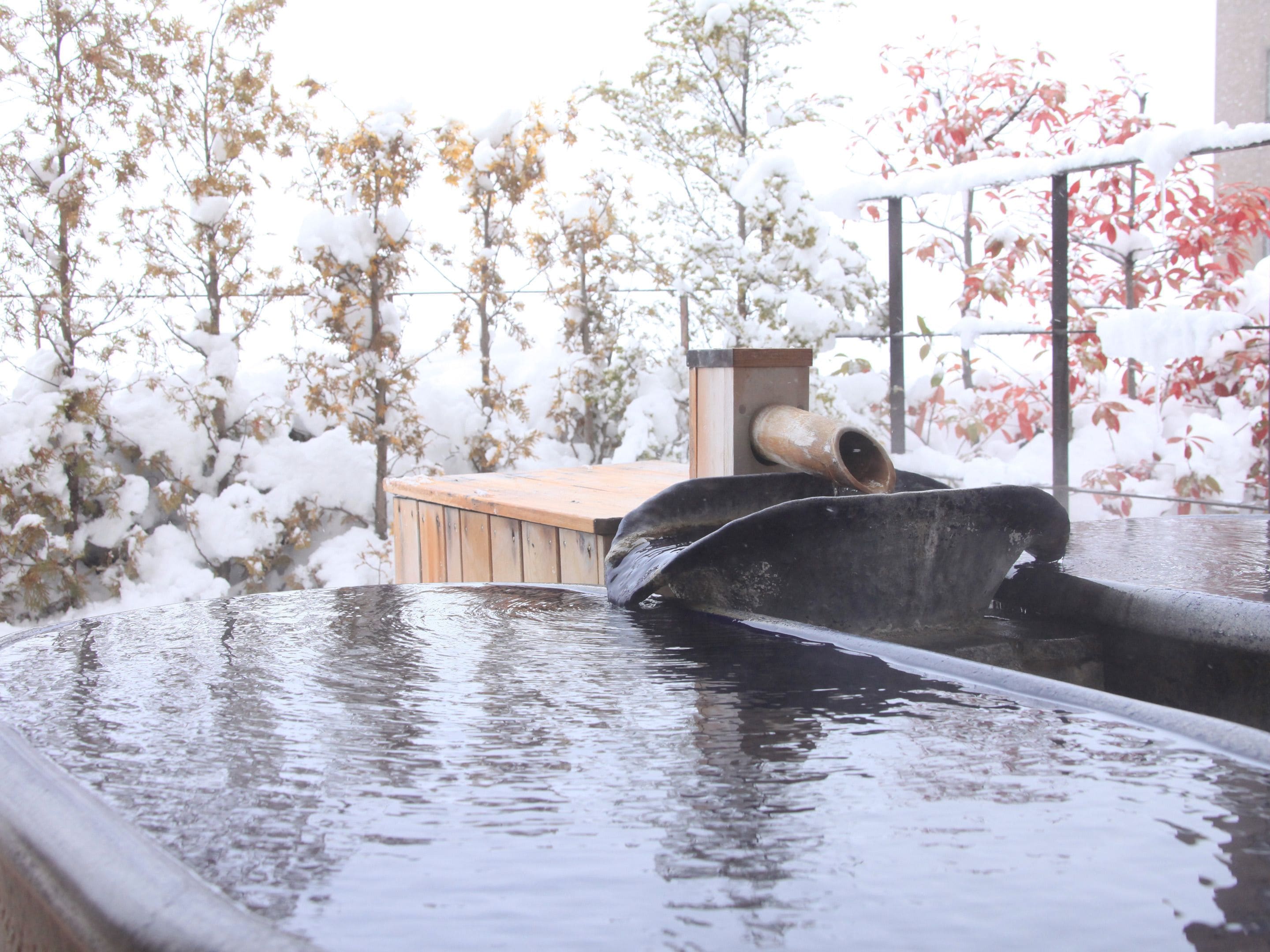 Un jacuzzi con una plataforma de madera y un caño metálico.