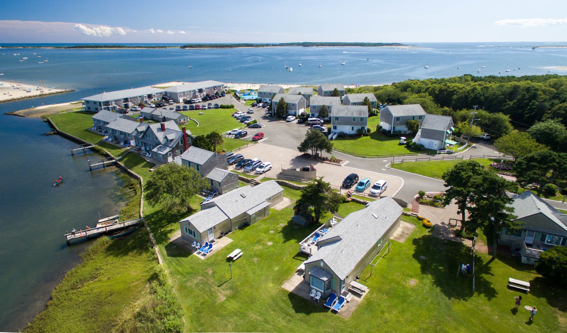 An aerial view of a coastal hotel with multiple buildings, a marina, and a beach.