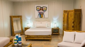 A room with a bed, a sofa, a glass-top table, and a mirror. - Hotel Plaza Yara (Quepos)