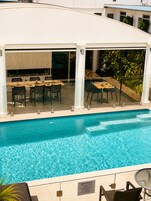 Una piscina al aire libre, sillones reclinables de piscina