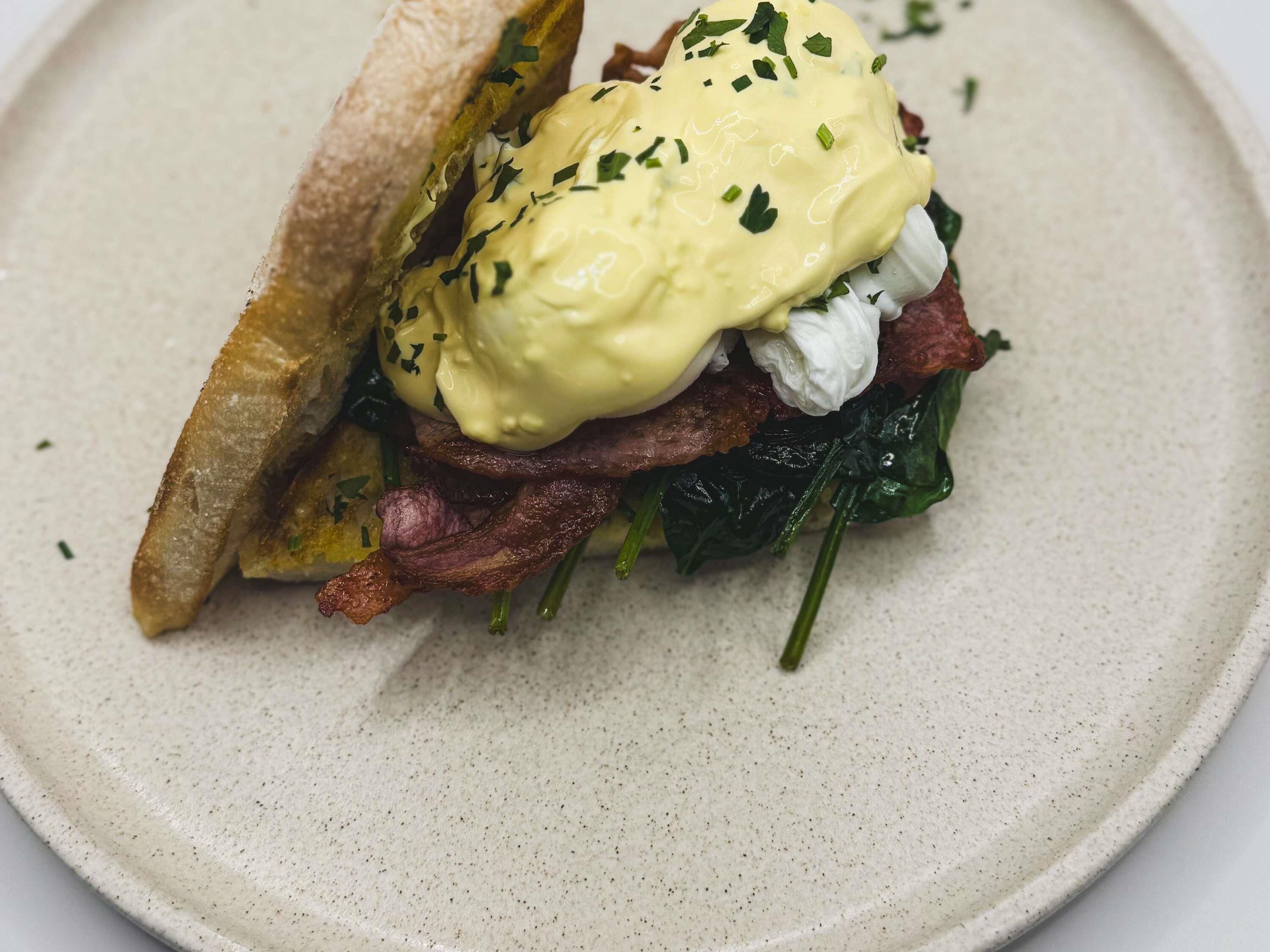 Un sandwich à l’œuf et au bacon, servi sur une assiette.