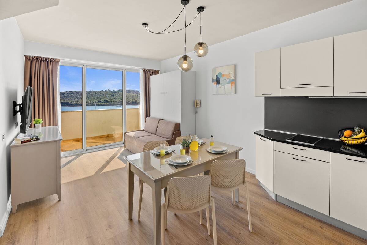 Una cocina moderna con comedor, sofá y vistas al exterior.