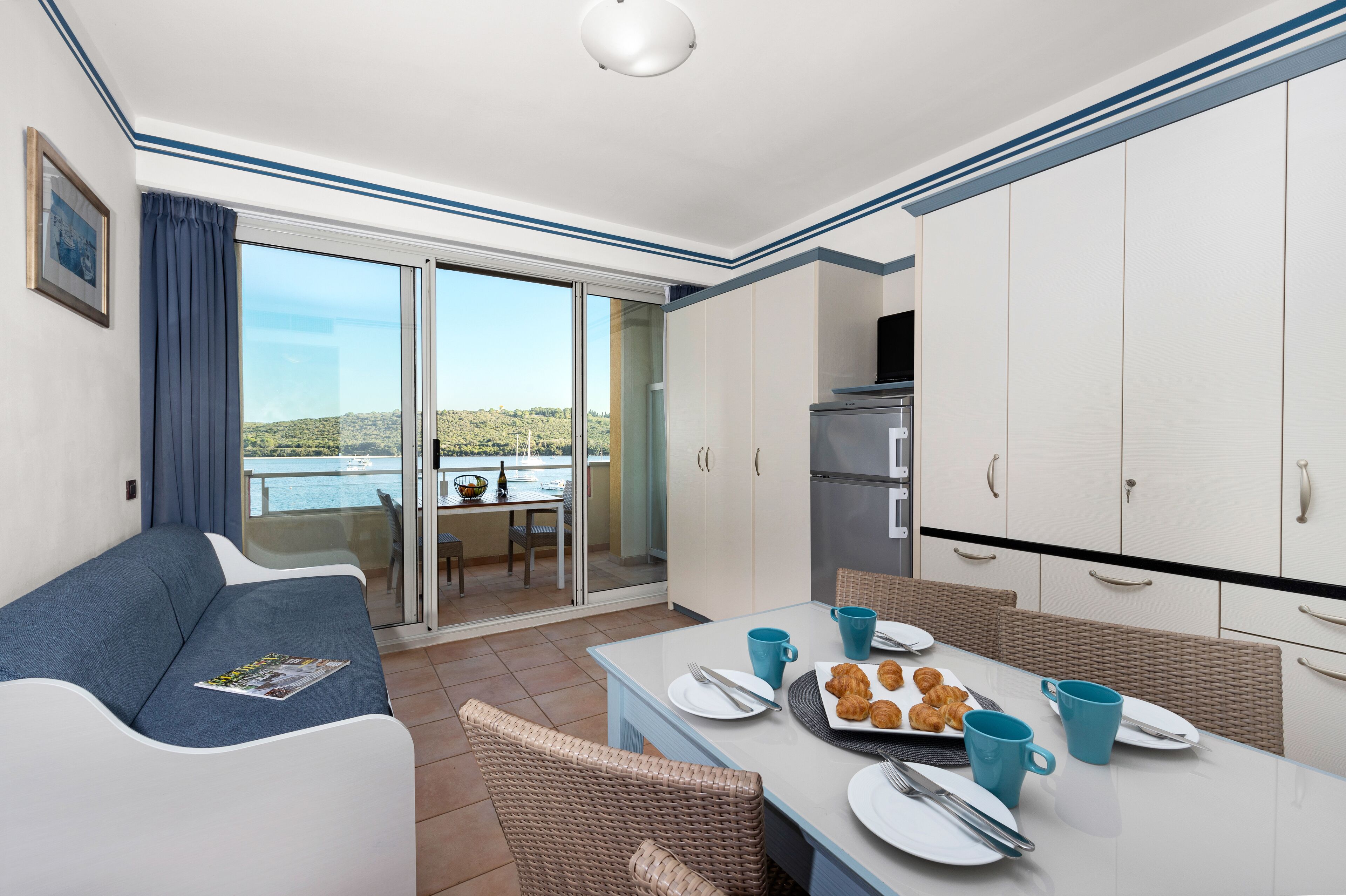 Una habitación moderna con sofá, mesa de comedor y preparación para el desayuno.