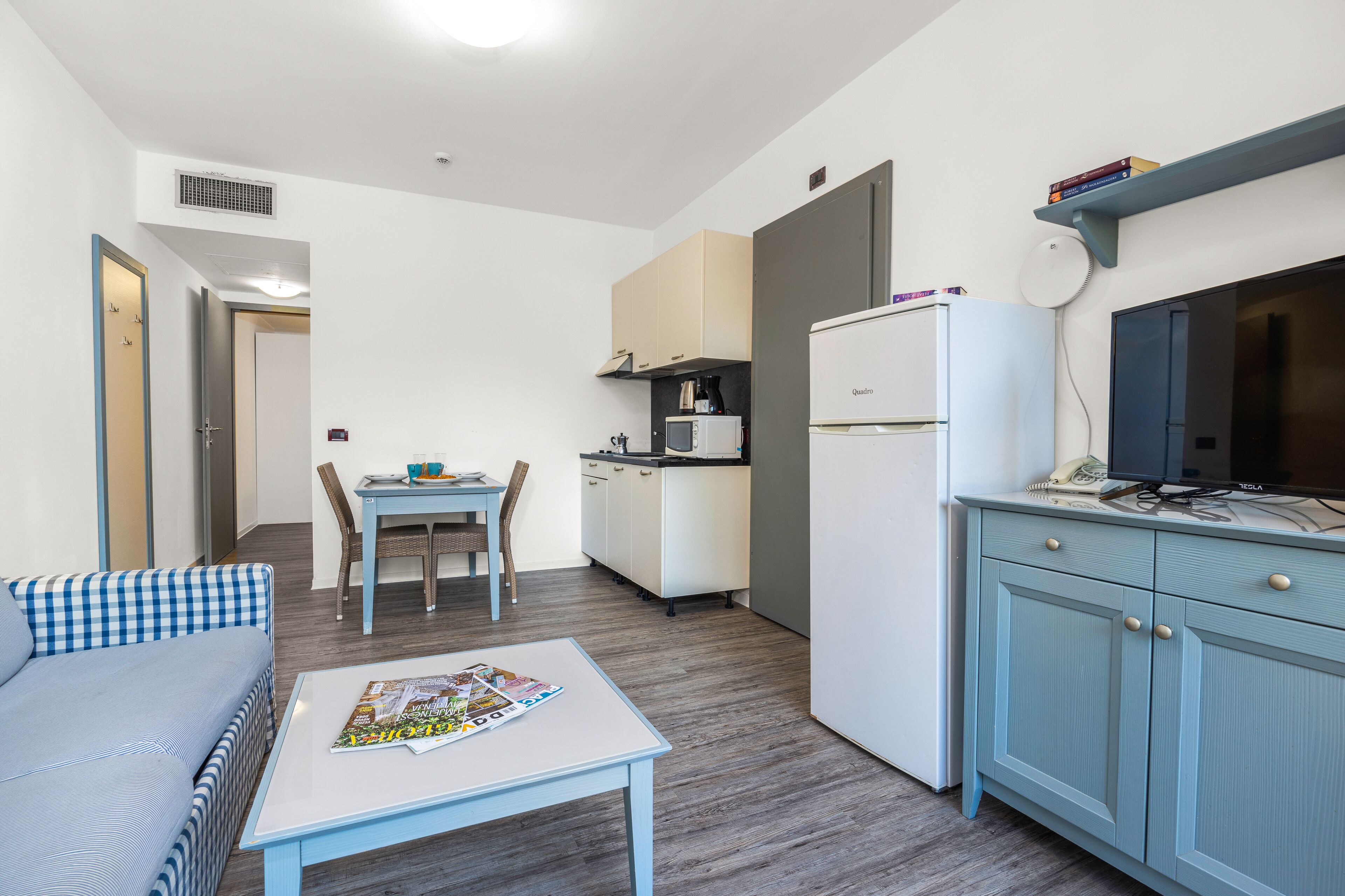 A compact living space with a kitchenette, a dining area, and a seating area.