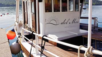 Een boot met een witte buitenkant, een dek en een bord met daarop 'del Mar APARTHOTEL'.