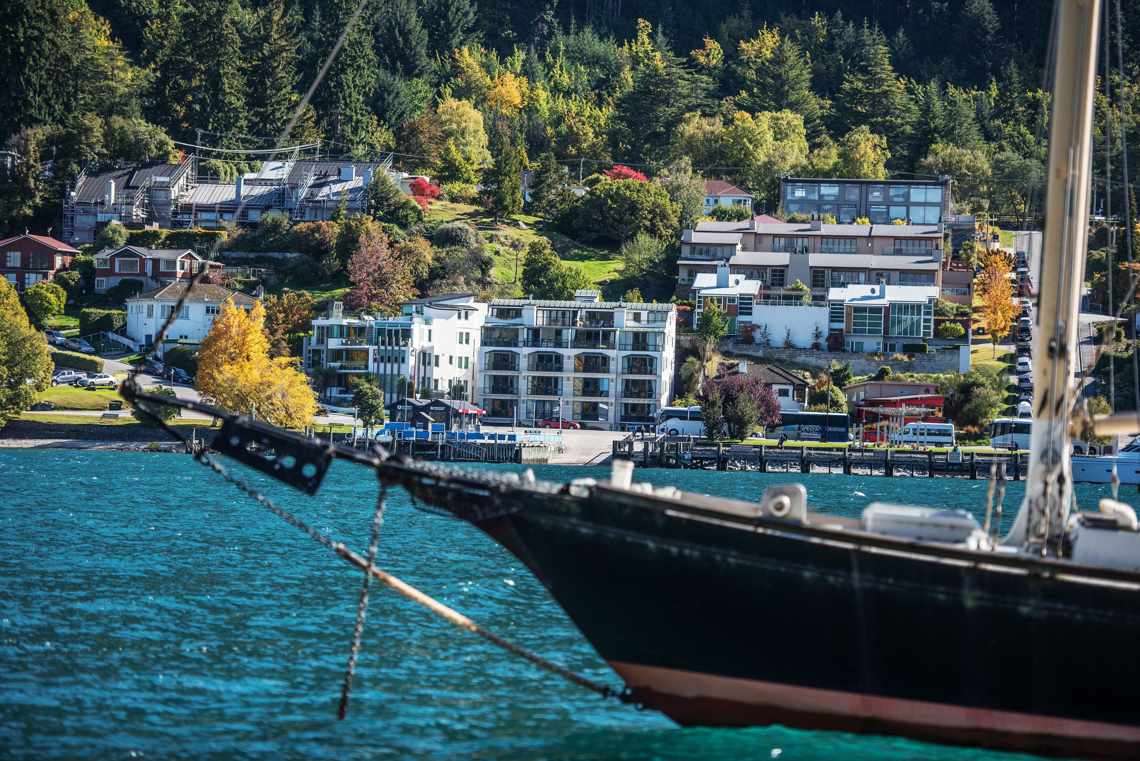 Une vue sur le front de mer, avec un bateau amarré au premier plan et des immeubles résidentiels en arrière-plan.