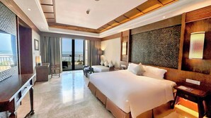 A hotel room with a large bed, a desk, and a balcony with a view. - Crowne Plaza Danang by IHG (Da Nang)