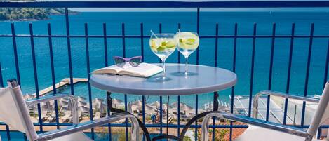 A balcony with a table, two chairs, and two glasses of drink.