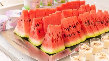 A tray of watermelon slices and glasses of a creamy beverage, likely yogurt or milkshake, on a countertop.