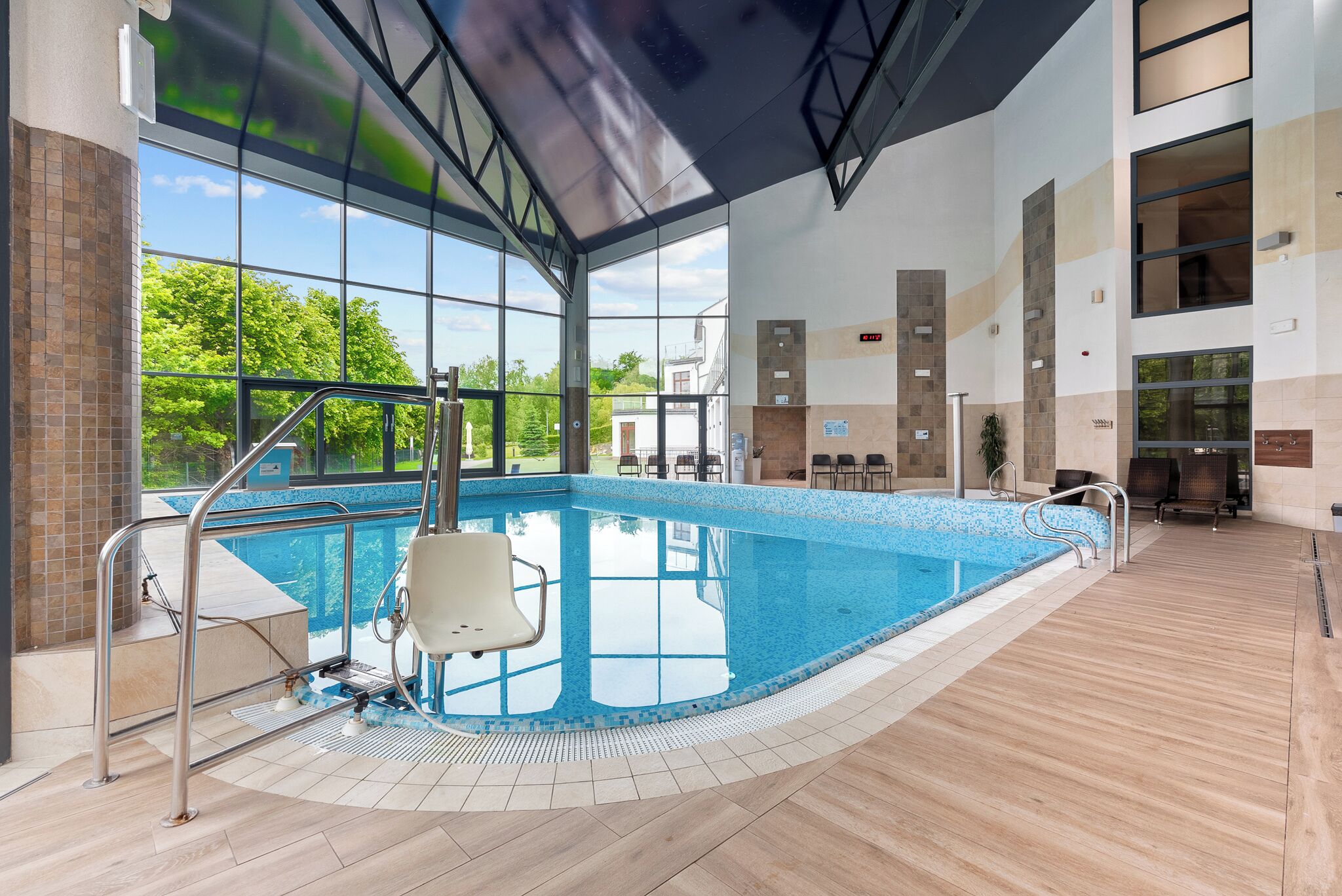 Una piscina techada, sillones reclinables de piscina