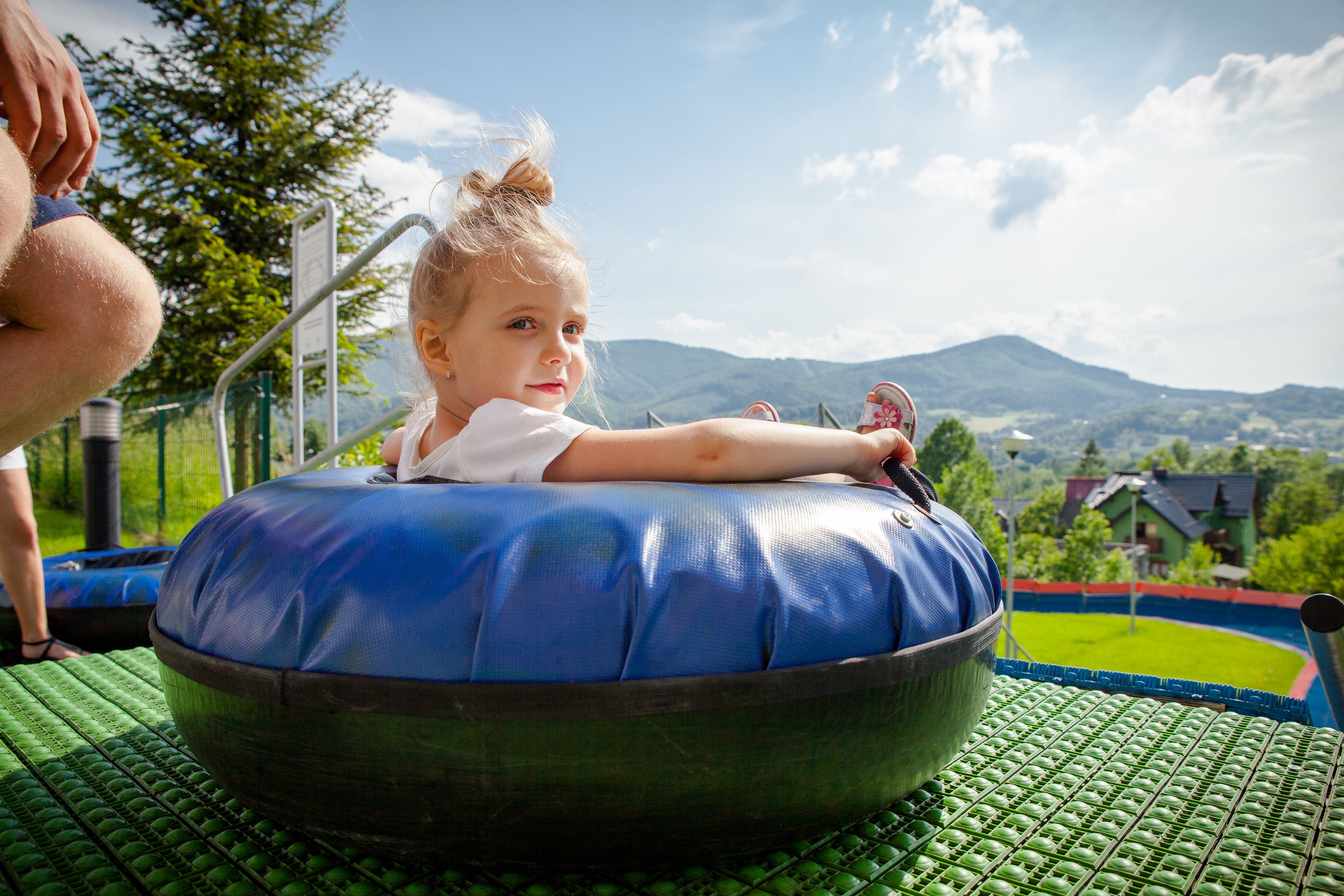 Un niño en un flotador azul con vistas panorámicas a las montañas.
