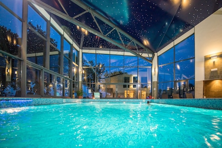 Una piscina techada, sillones reclinables de piscina