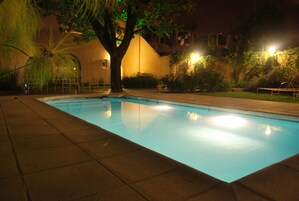 Una piscina al aire libre, sillones reclinables de piscina