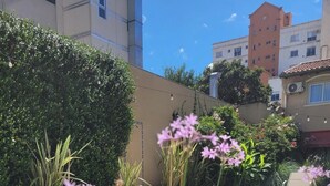 Une piscine entourée de verdure et de bâtiments.
