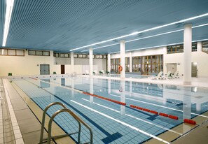 An indoor swimming pool with clear lanes, a tiled floor, and a ceiling with linear lights. - TH La Thuile - Planibel Hotel (La Thuile)