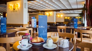 Ein Restaurantambiente mit Tischen, Stühlen und einer Theke mit der Aufschrift 'La Place'.