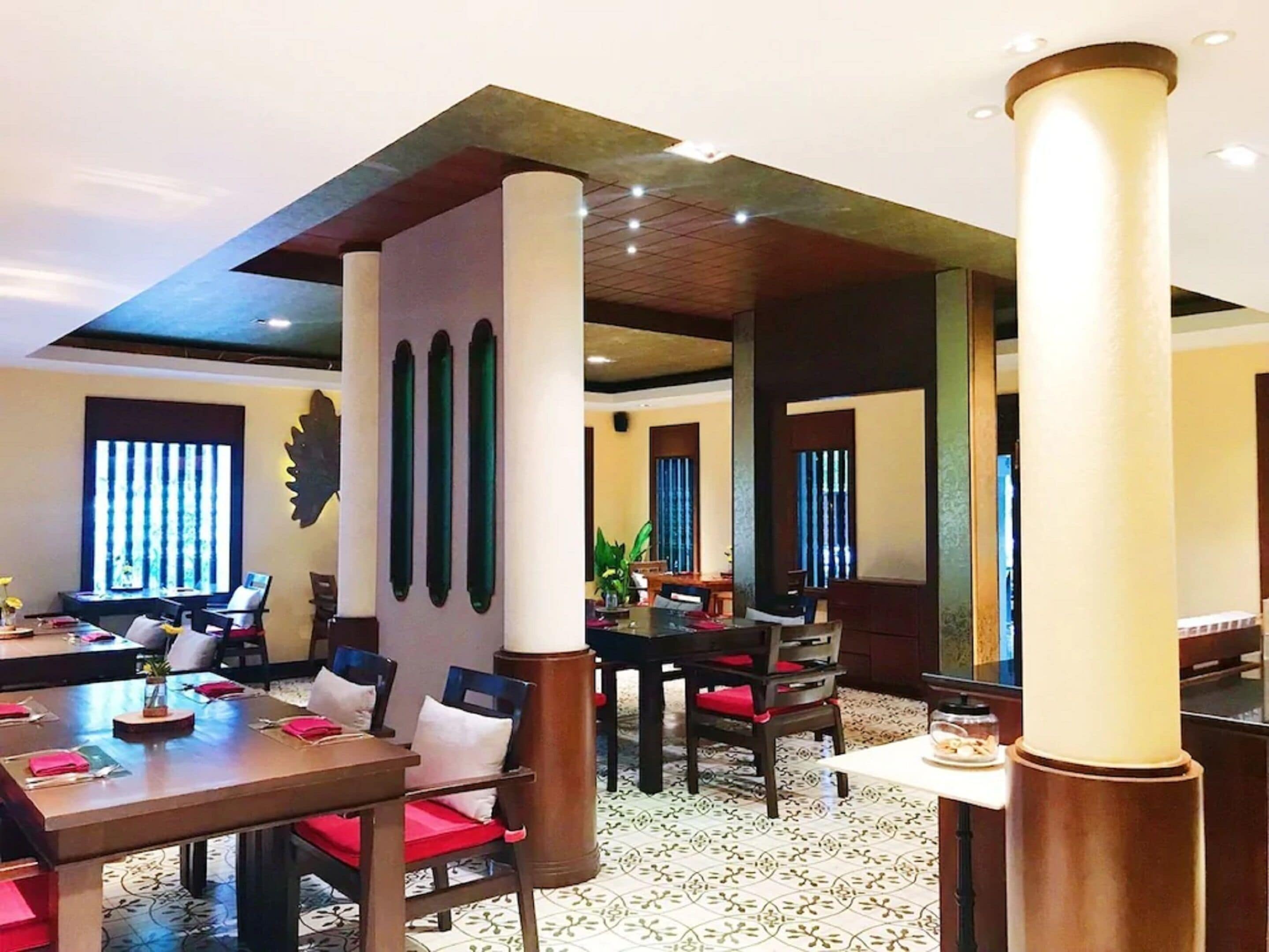 Ein Restaurant mit hohen Decken, großen Fenstern und moderner Einrichtung.