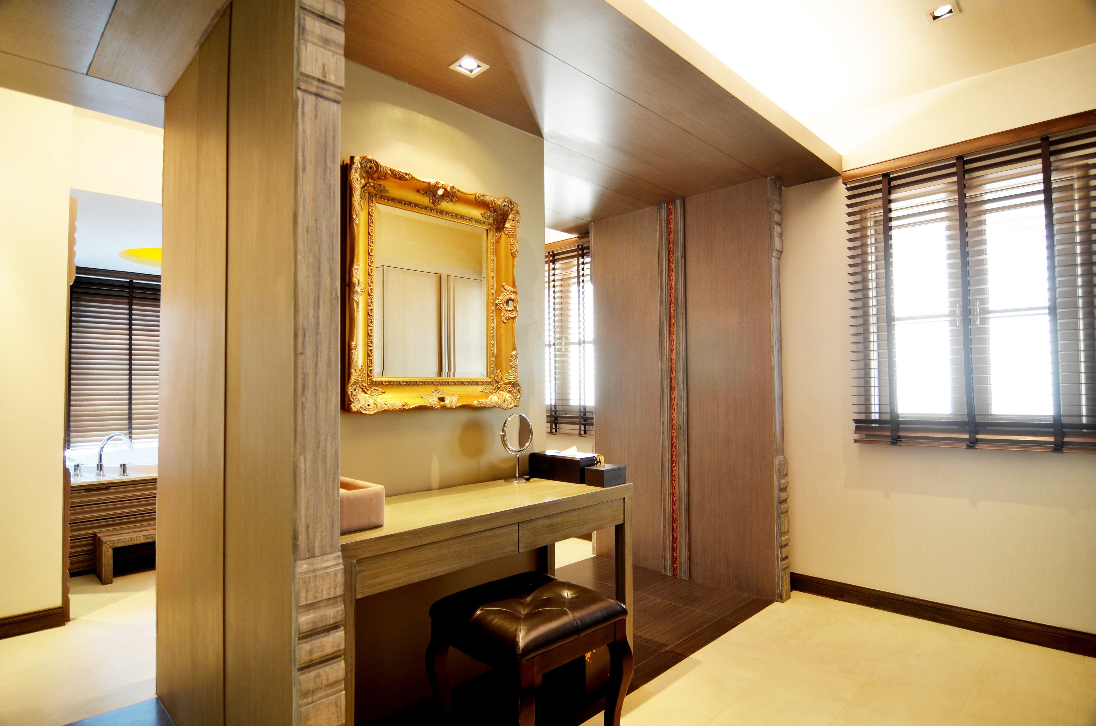 A bathroom with a vanity, mirror, and window with blinds.