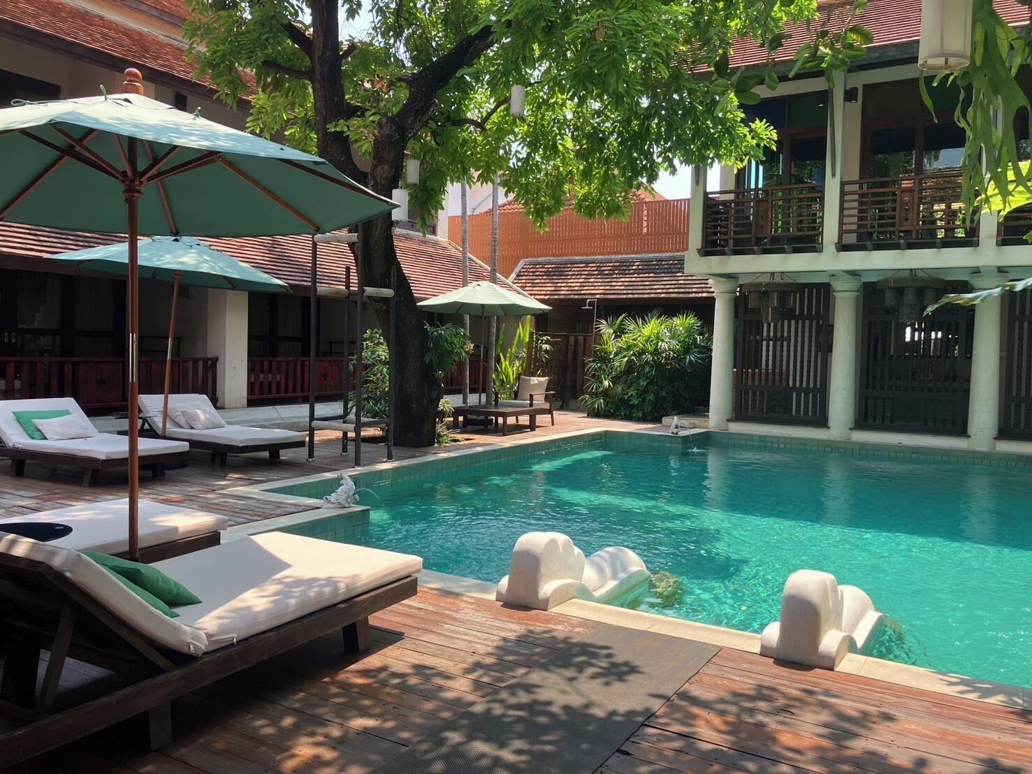 Una piscina al aire libre, sillones reclinables de piscina