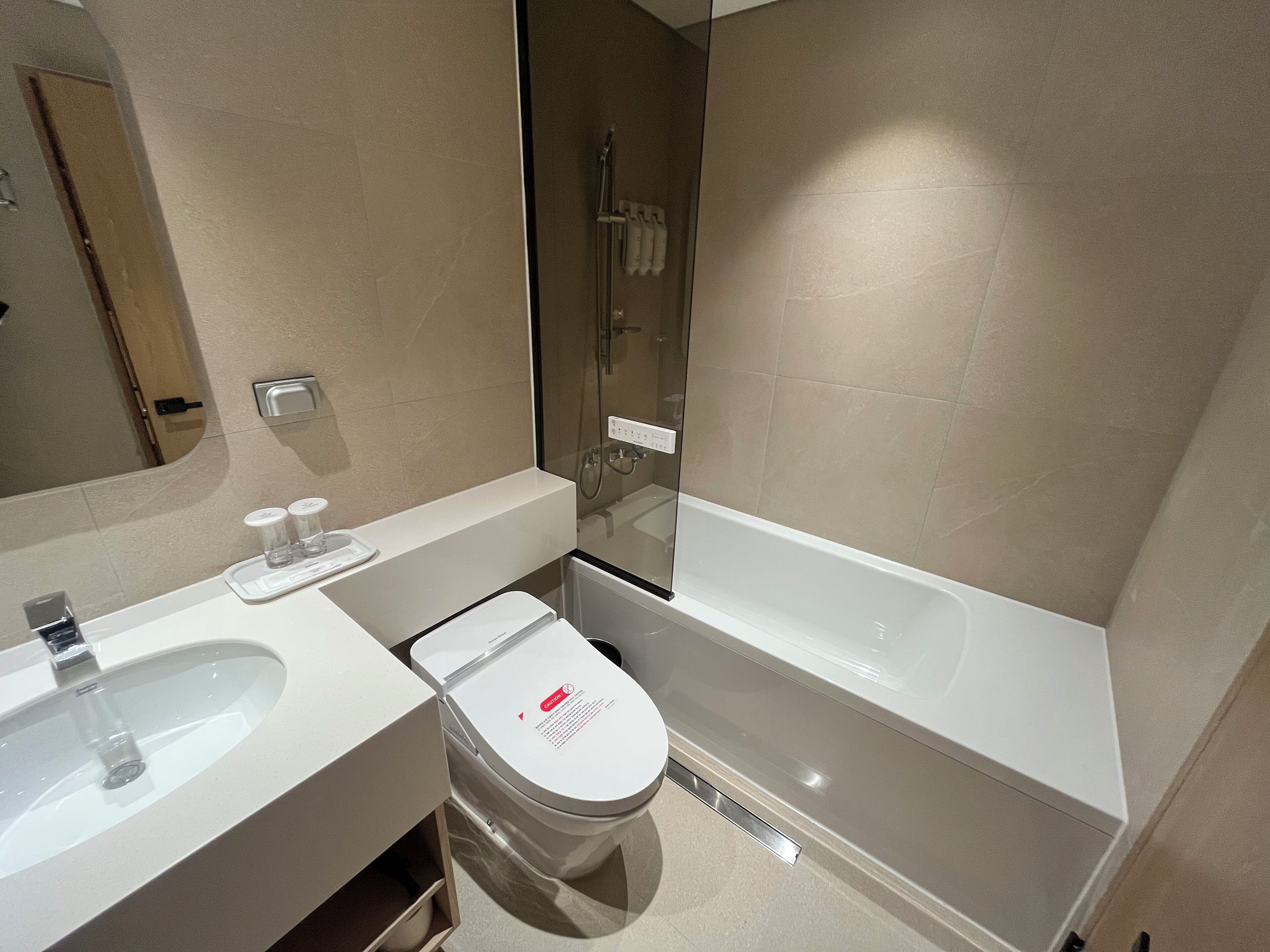 A modern bathroom with a white sink, toilet, and bathtub.