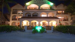 A hotel with a prominent sign reading "The Palm's" and multiple balconies. - The Palms Oceanfront Suites (San Pedro)