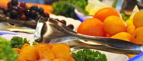 Ein Buffet mit verschiedenen Früchten und Gemüsesorten, darunter Orangen und Brokkoli.