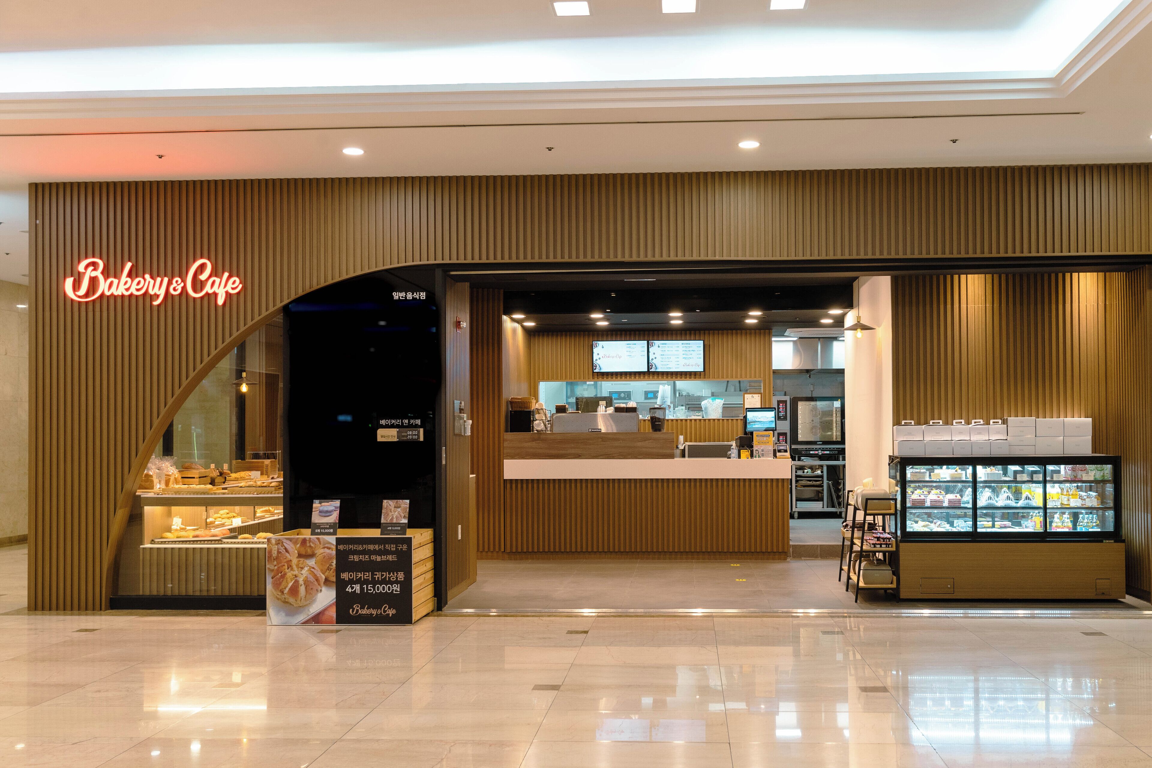 A bakery cafe with a modern interior, a counter, and a display case with baked goods.