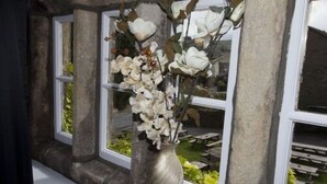 En vase med hvide blomster står på et vindueskar