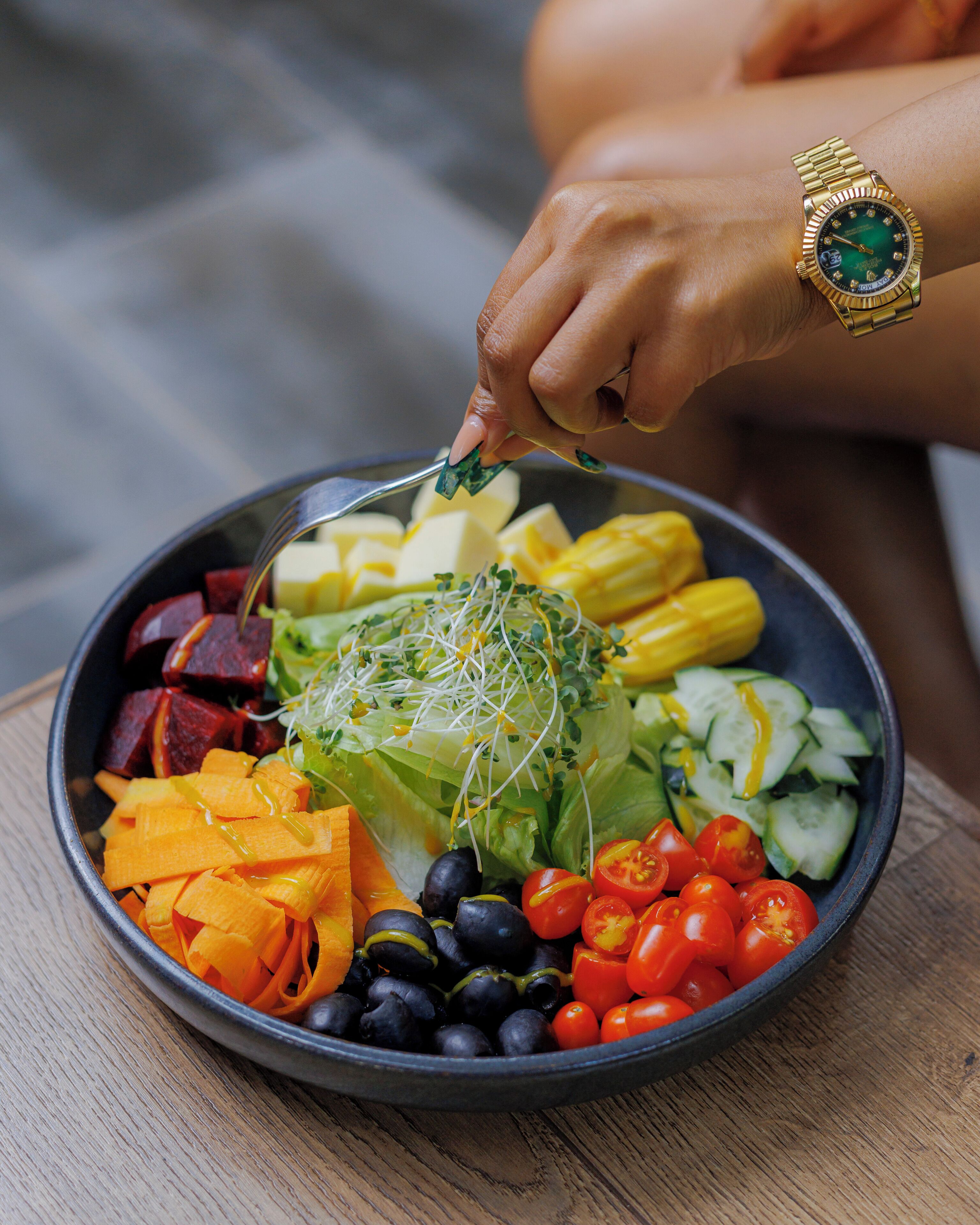 Un tazón de ensalada colorida con diversas verduras y brotes.