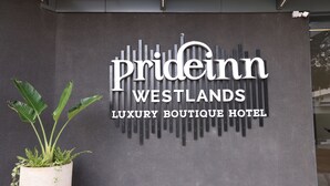 A sign for the Prideinn Westlands Luxury Boutique Hotel with a modern design and a potted plant beside it. - PrideInn Westlands Luxury Boutique Hotel (Nairobi)
