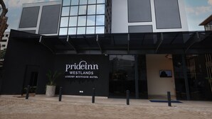 A modern building with a glass facade and a sign reading "Prideinn Westlands Luxury Boutique Hotel". - PrideInn Westlands Luxury Boutique Hotel (Nairobi)