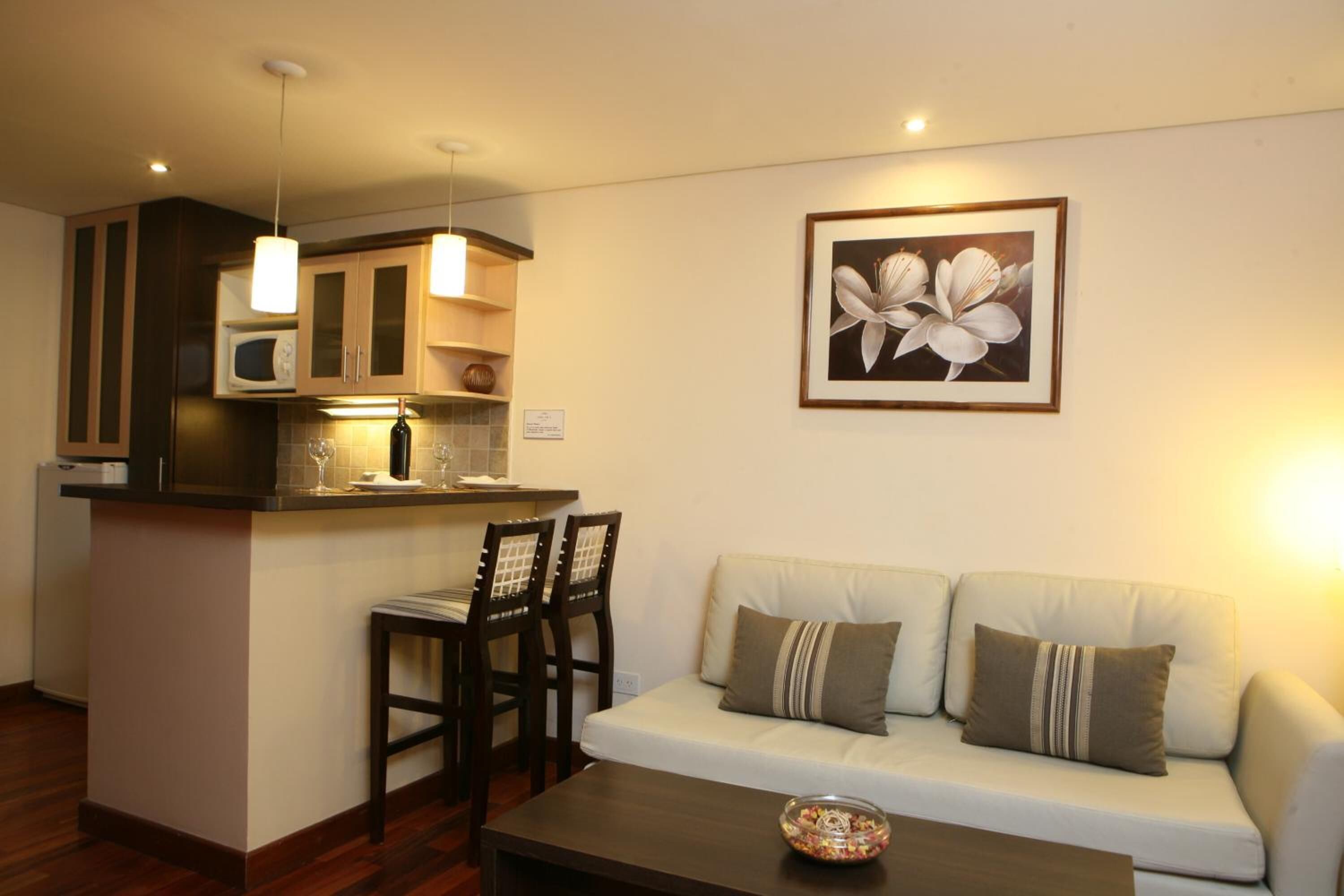 A compact living space with a kitchenette, a sofa, and a dining area.