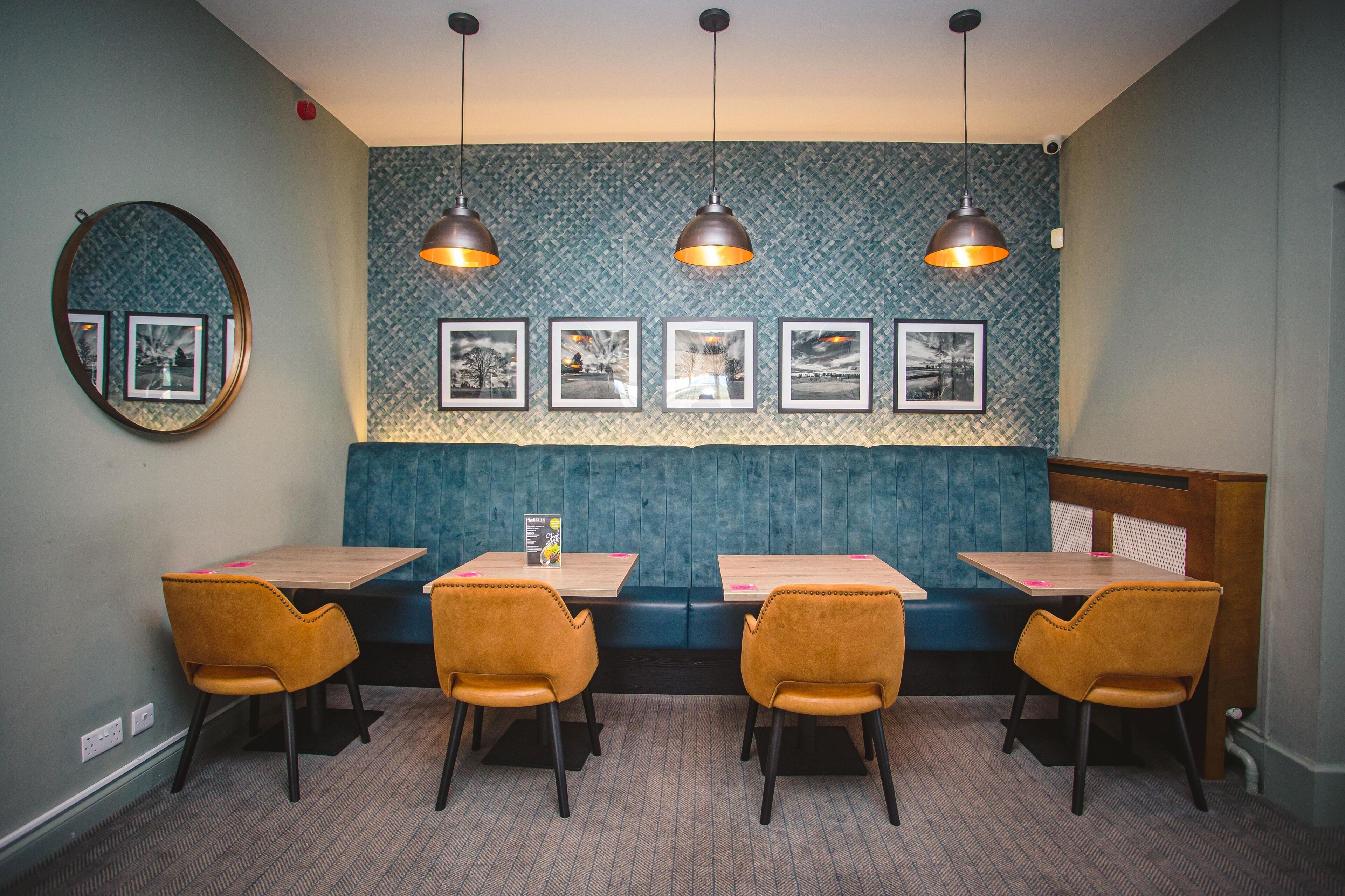 Un restaurant avec des banquettes bleues, des tables en bois et des chaises orange.