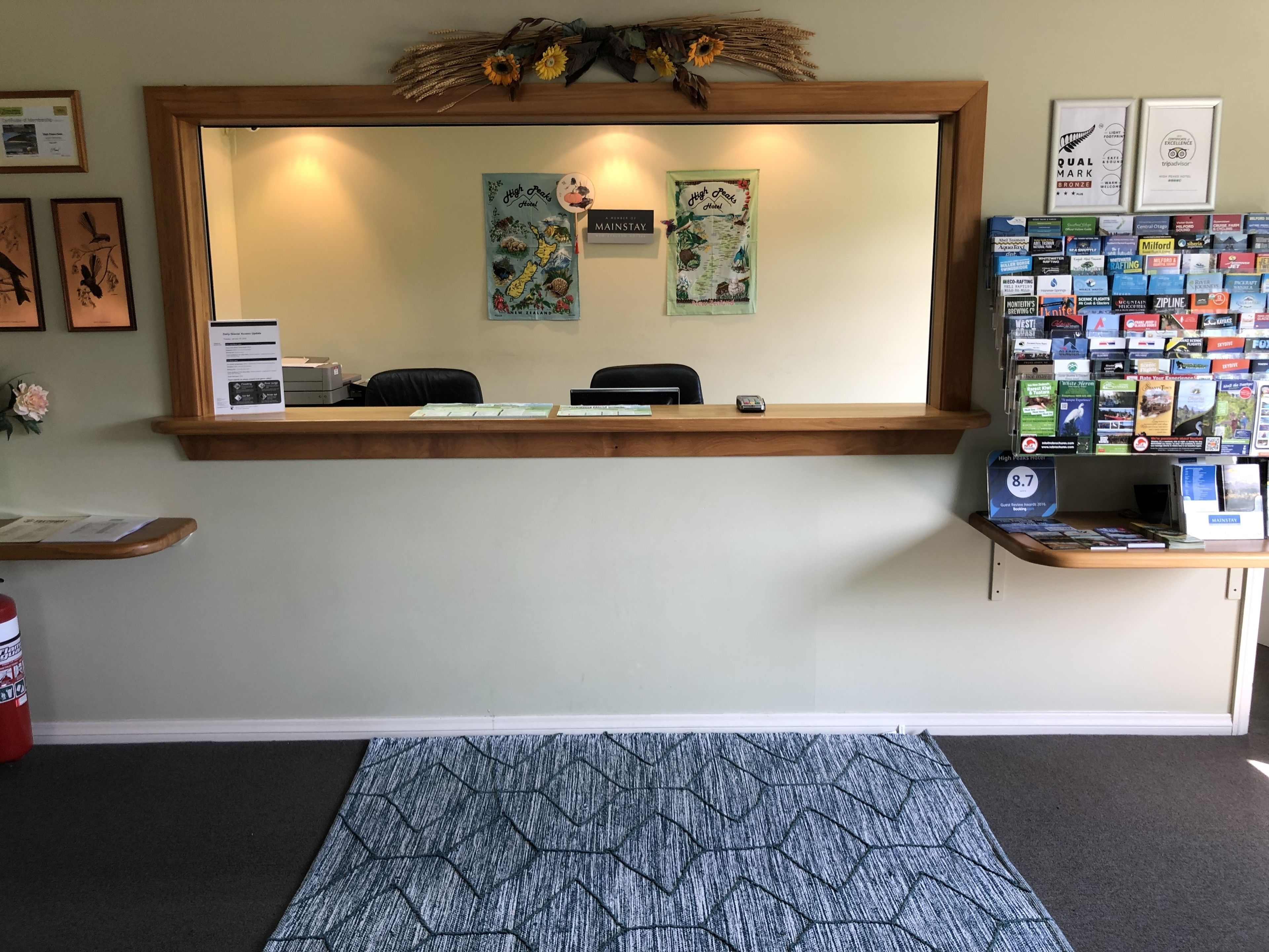 A reception desk with framed awards, a bulletin board, and a display of local attractions.