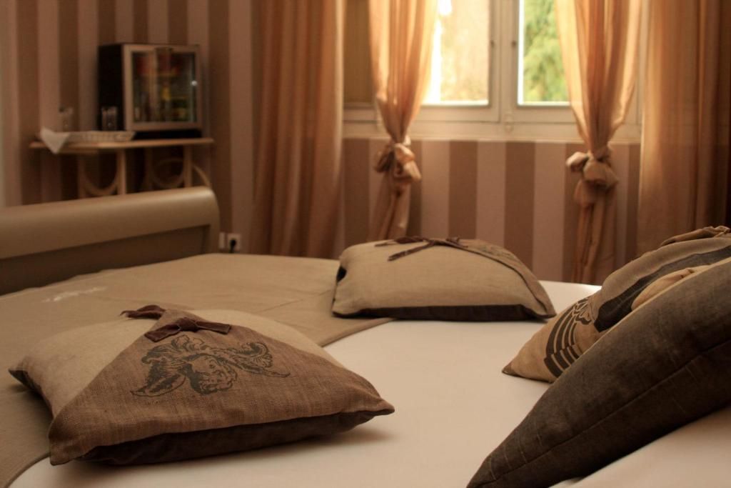 Un dormitorio con cama, almohadas, una mesita de noche y cortinas.