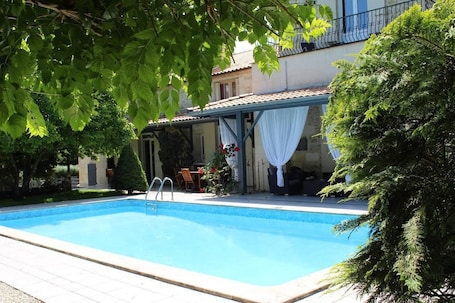 Una piscina al aire libre de temporada, sombrillas. Château la Moune