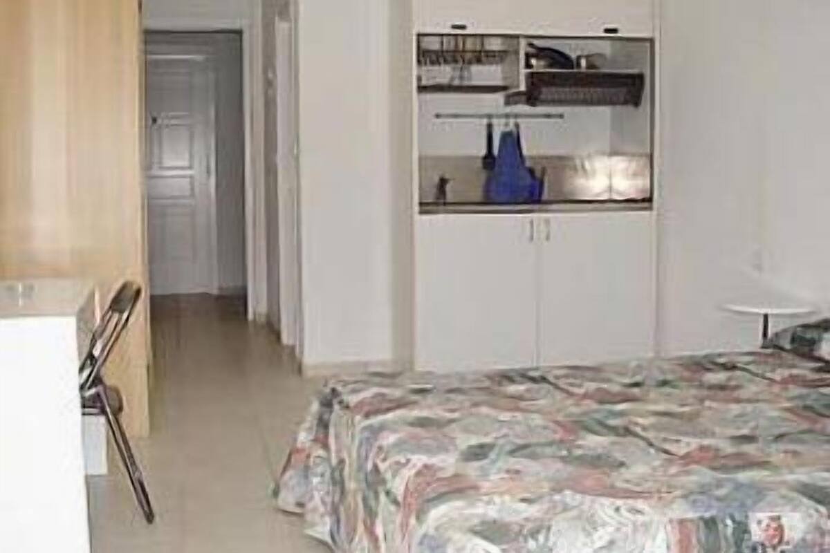 Ein Schlafzimmer mit Bett, Schreibtisch und Kleiderschrank.
