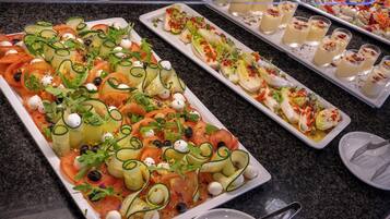 A buffet with various dishes, including salads and appetizers, arranged on a counter.