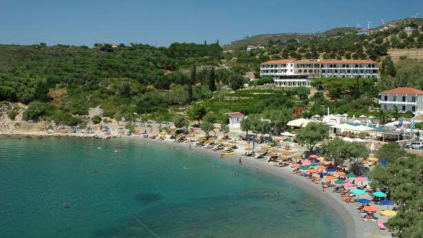 Un hotel costero con varios pisos, acceso a la playa y vistas al mar.
