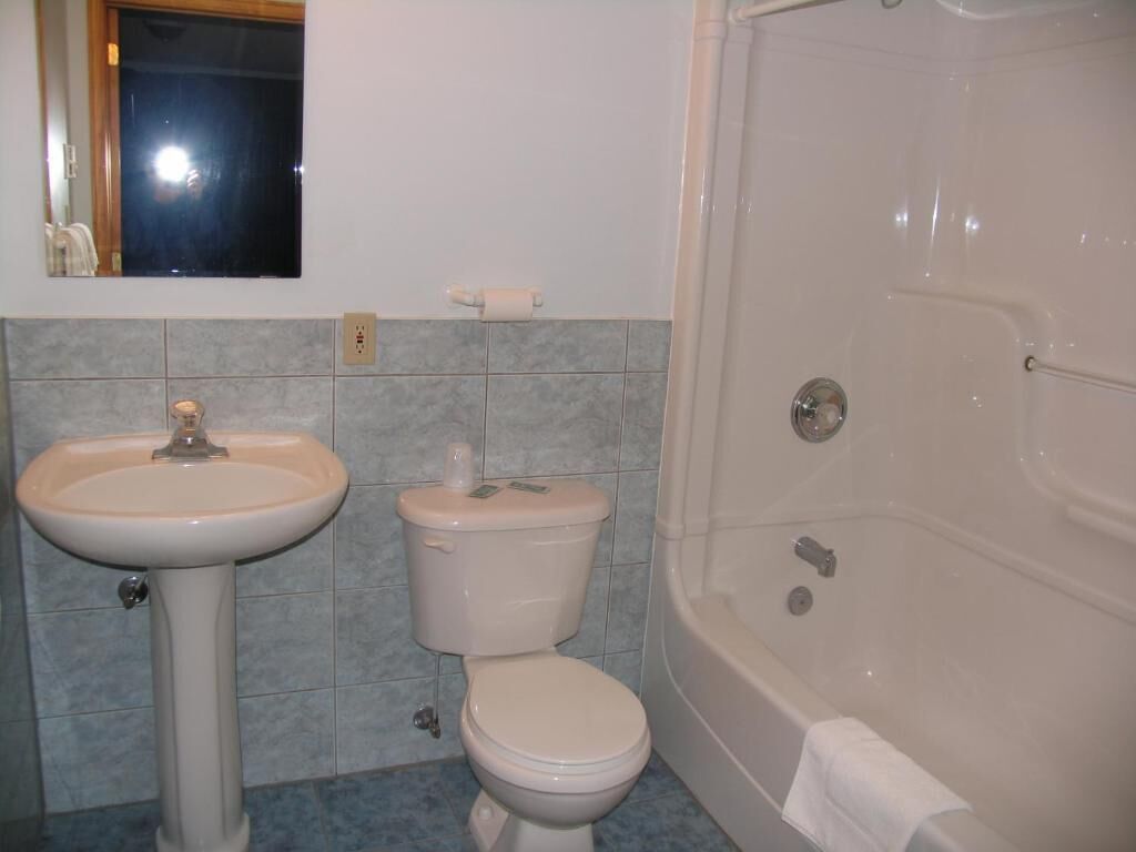 A bathroom with a sink, toilet, and bathtub.