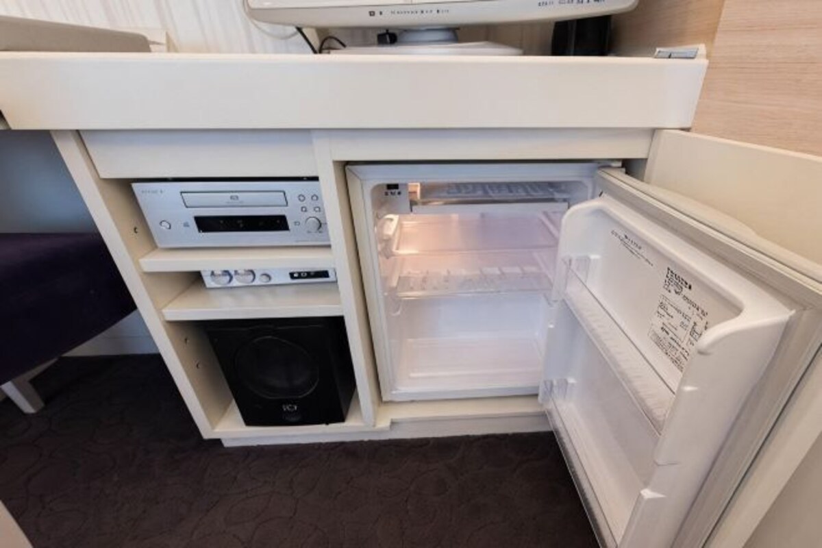A compact kitchenette with a microwave, a small refrigerator, and a built-in oven.