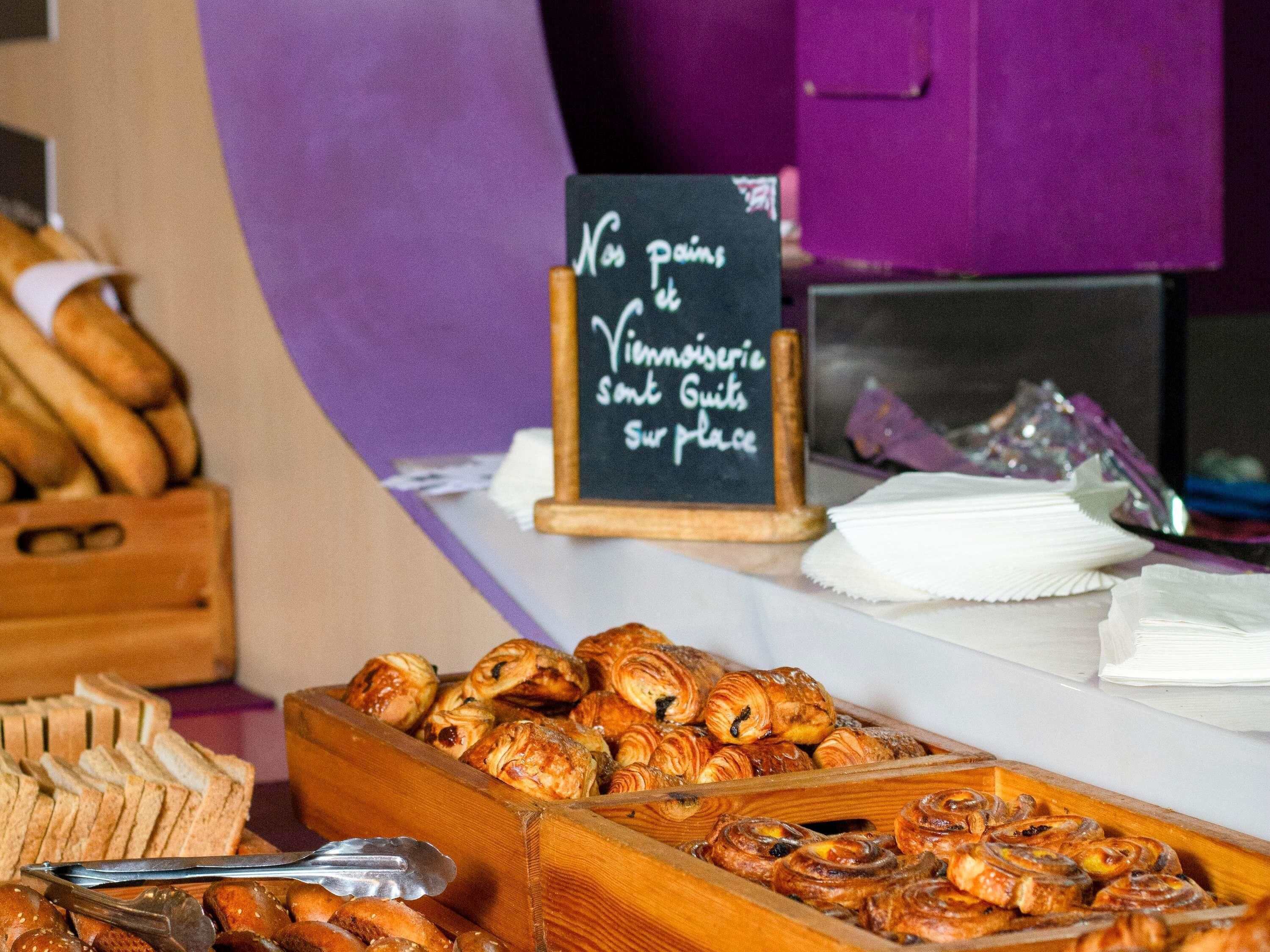 A bakery display with pastries and a sign that reads 'No pains, Vinoiserie, Some Guit, Sur place.'